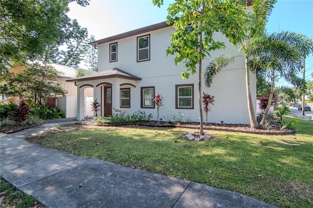 view of front of house with stucco siding and a front yard
