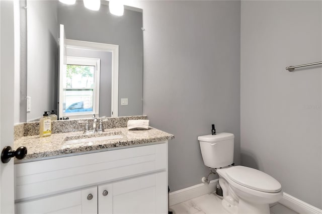 bathroom featuring baseboards, vanity, toilet, and marble finish floor