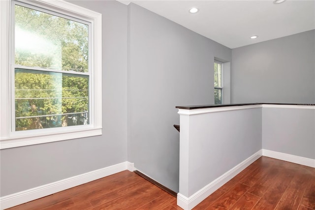 hallway featuring baseboards, recessed lighting, and dark wood-style flooring