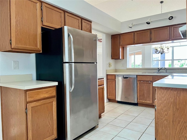 114 Clays Trl Unit 114, Oldsmar, FL 34677 - kitchen featuring stainless steel appliances, a sink, light tile patterned flooring, light countertops, and brown cabinetry