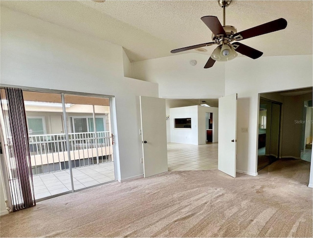 114 Clays Trl Unit 114, Oldsmar, FL 34677 - tiled spare room featuring carpet floors, ceiling fan, a textured ceiling, baseboards, and high vaulted ceiling