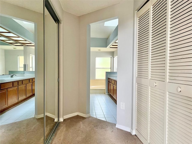 114 Clays Trl Unit 114, Oldsmar, FL 34677 - hall with light tile patterned floors, light colored carpet, baseboards, and a sink