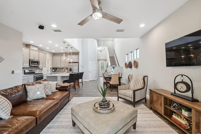 17537 Brighton Lake Rd, Land O Lakes, FL 34638 - living room featuring baseboards, visible vents, ceiling fan with notable chandelier, and light wood-type flooring