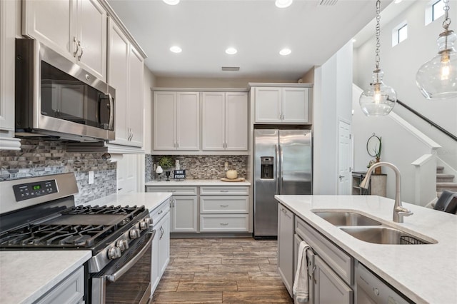 17537 Brighton Lake Rd, Land O Lakes, FL 34638 - kitchen with a sink, light countertops, stainless steel appliances, wood finished floors, and pendant lighting