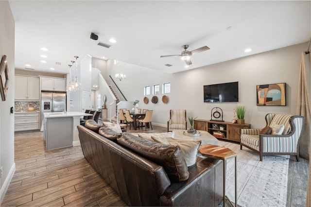 17537 Brighton Lake Rd, Land O Lakes, FL 34638 - living room with visible vents, stairs, recessed lighting, light wood-style flooring, and ceiling fan with notable chandelier