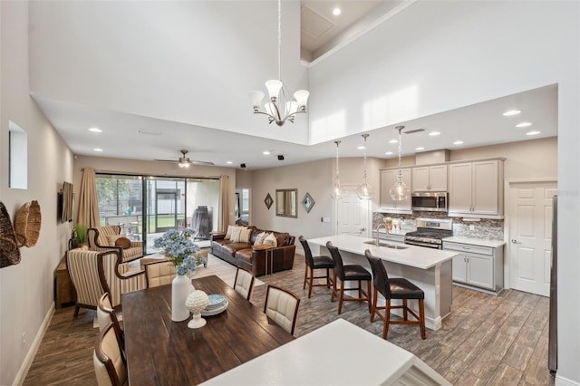 17537 Brighton Lake Rd, Land O Lakes, FL 34638 - dining room featuring baseboards, recessed lighting, wood finished floors, and a towering ceiling