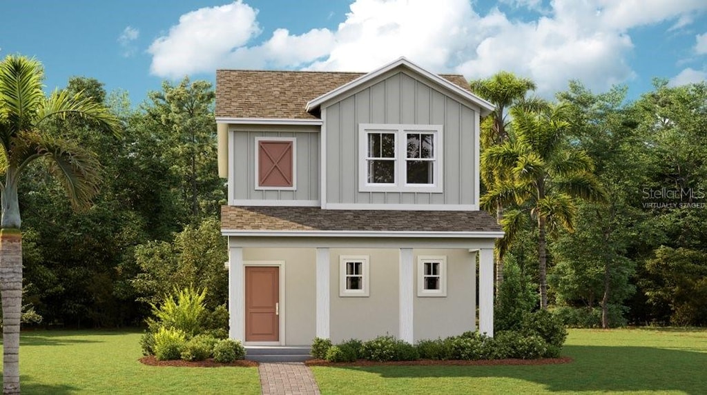 view of front facade featuring a shingled roof, board and batten siding, stucco siding, and a front yard
