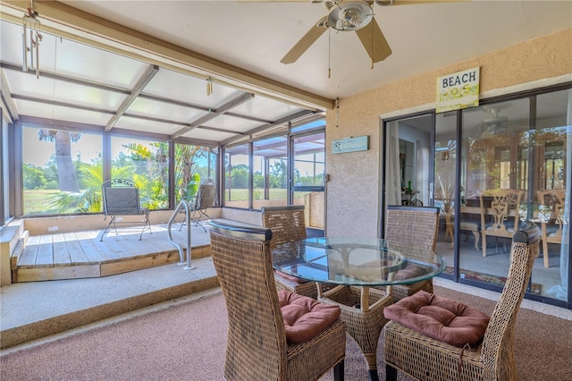 sunroom / solarium with outdoor dining space, ceiling fan, and beamed ceiling