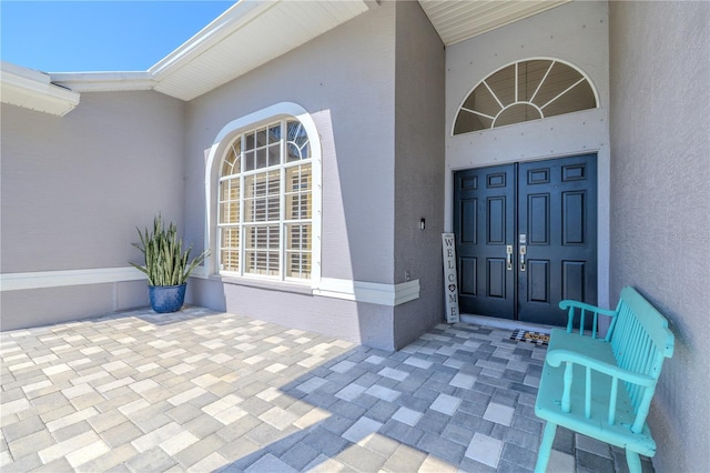 view of exterior entry with stucco siding