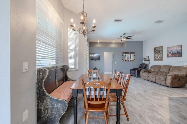 dining space featuring ceiling fan with notable chandelier and visible vents