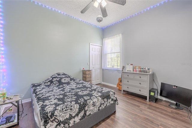 bedroom with baseboards, a textured ceiling, ceiling fan, and wood finished floors