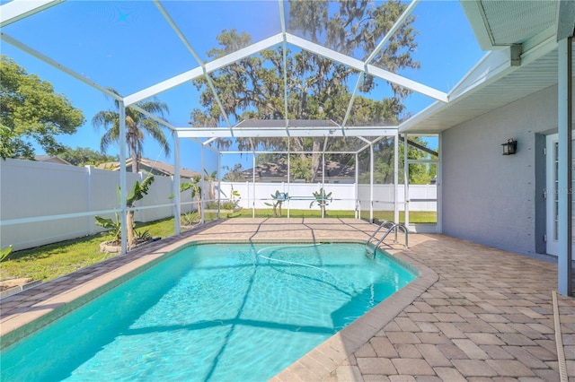 view of pool with a patio, a fenced backyard, glass enclosure, and a fenced in pool