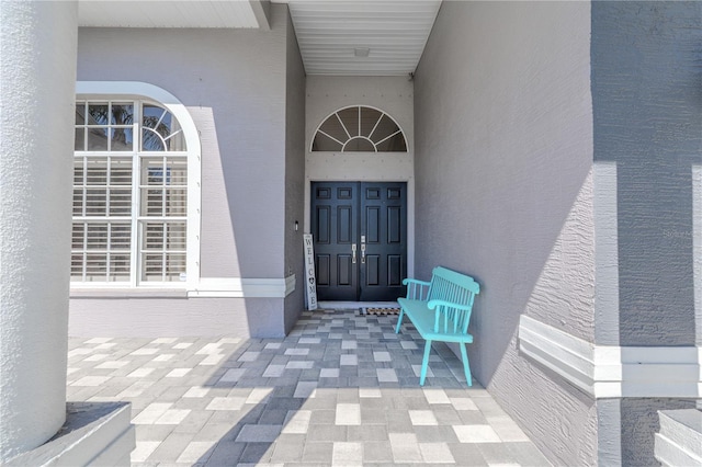 entrance to property featuring stucco siding