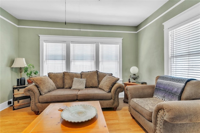 living area featuring baseboards and light wood-type flooring