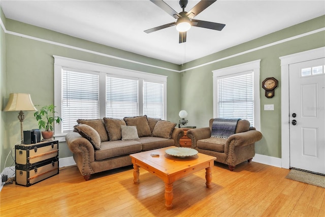 living area with light wood-style floors, baseboards, and ceiling fan