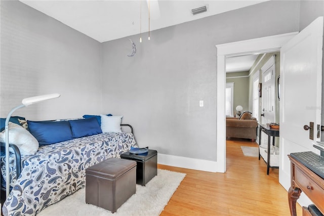 bedroom with baseboards, visible vents, and light wood-style floors
