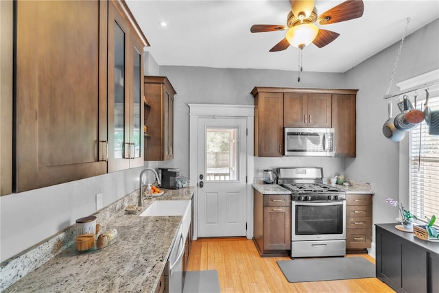 kitchen with light wood-style floors, ceiling fan, plenty of natural light, a sink, and appliances with stainless steel finishes