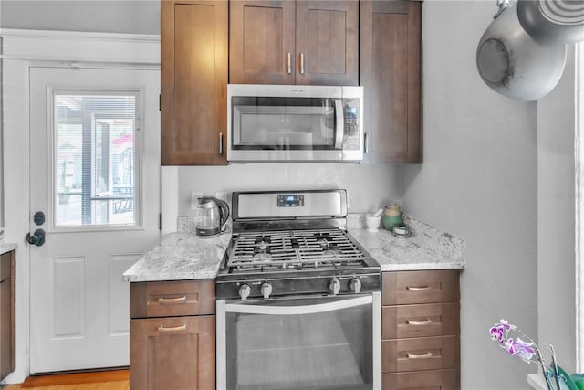 kitchen featuring light stone counters and appliances with stainless steel finishes