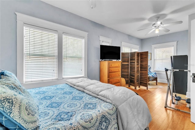 bedroom featuring baseboards, ceiling fan, and light wood-style flooring