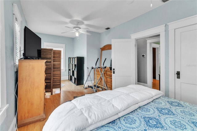 bedroom with ceiling fan, visible vents, multiple windows, and light wood-type flooring