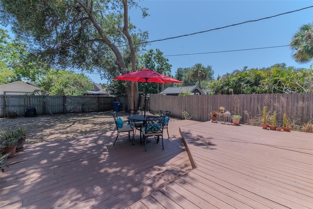 wooden terrace featuring a fenced backyard and outdoor dining space