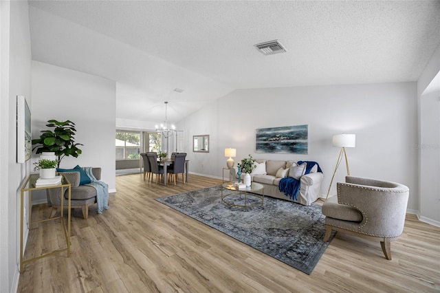 11218 Sun Tree Rd, Hudson, FL 34667 - living area with a chandelier, light wood-style flooring, vaulted ceiling, and a textured ceiling