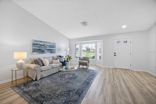 11218 Sun Tree Rd, Hudson, FL 34667 - living room with light wood-style floors, vaulted ceiling, and recessed lighting