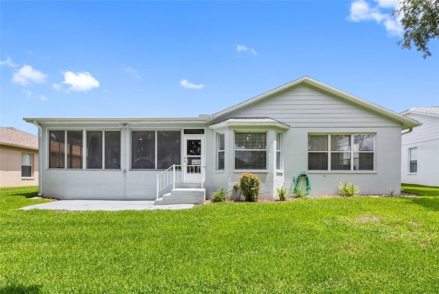 11218 Sun Tree Rd, Hudson, FL 34667 - rear view of house with a sunroom and a lawn