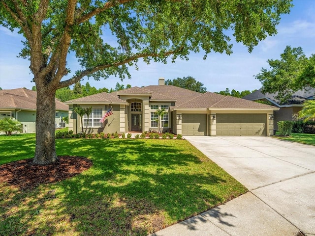 view of front of home featuring a front lawn, a garage, driveway, a chimney, and stucco siding