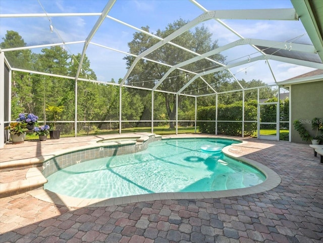 view of pool featuring a patio, glass enclosure, and a pool with connected hot tub