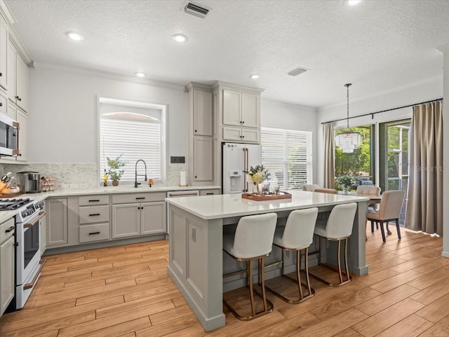 kitchen featuring a center island, light countertops, visible vents, and white appliances