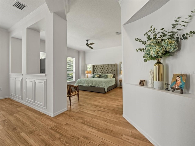 bedroom featuring a textured ceiling, visible vents, and light wood-type flooring