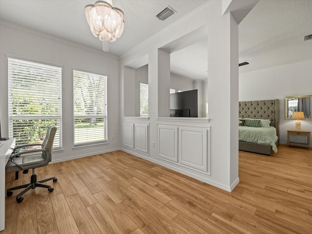 home office featuring an inviting chandelier, visible vents, crown molding, and light wood-style floors