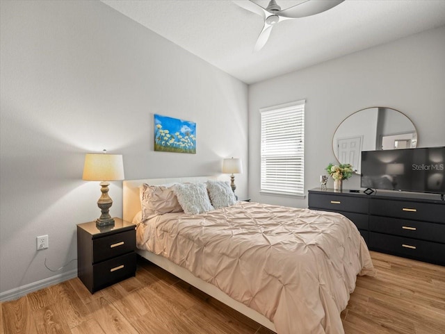 bedroom with baseboards, light wood-type flooring, and a ceiling fan
