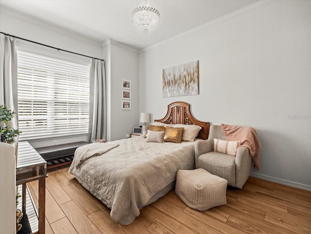 bedroom featuring light wood-type flooring, crown molding, and baseboards