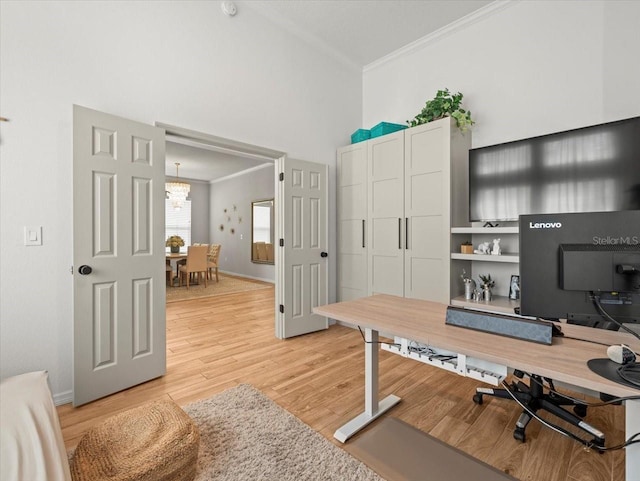 office space with ornamental molding, a notable chandelier, a high ceiling, and light wood-style flooring