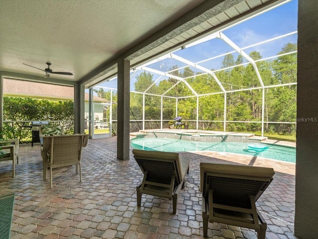 view of patio / terrace featuring a lanai, a ceiling fan, and a pool with connected hot tub