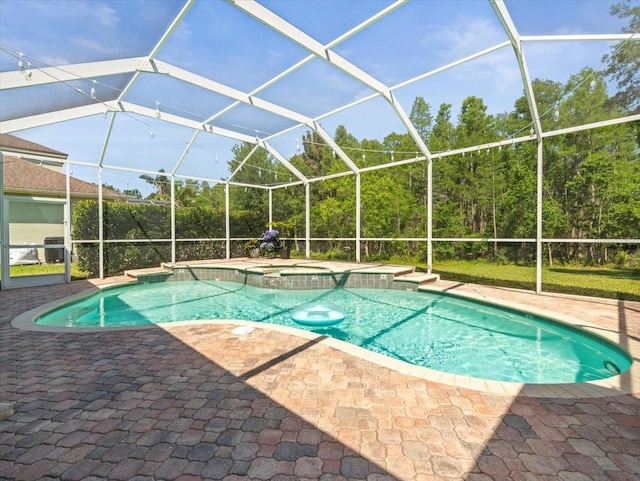 view of swimming pool featuring a patio, glass enclosure, and a pool with connected hot tub