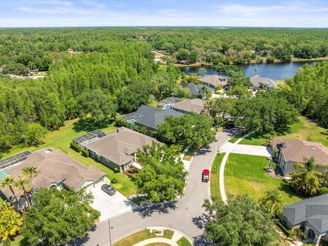 aerial view featuring a residential view, a water view, and a view of trees