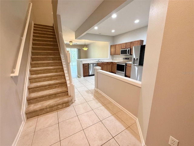 26514 Chimney Spire Ln, Wesley Chapel, FL 33544 - kitchen with appliances with stainless steel finishes, a peninsula, a sink, recessed lighting, and light tile patterned flooring