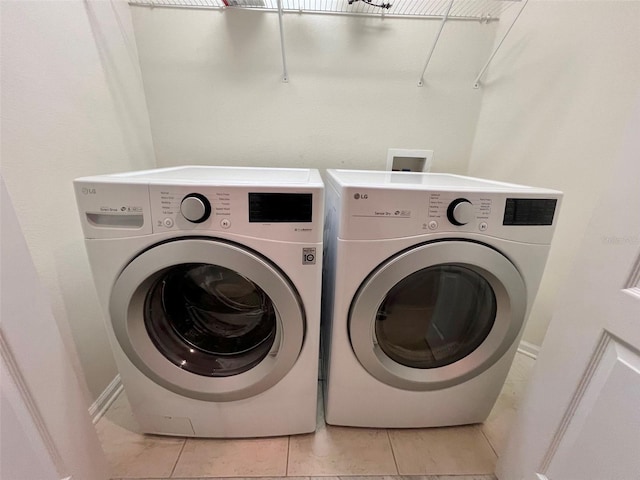 26514 Chimney Spire Ln, Wesley Chapel, FL 33544 - washroom with washer and clothes dryer, light tile patterned flooring, and baseboards
