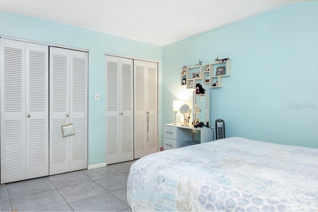 bedroom featuring light tile patterned flooring and two closets