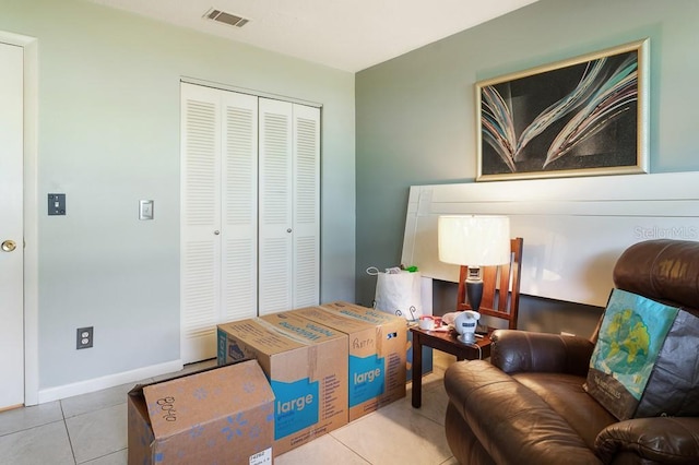 living area featuring baseboards, visible vents, and tile patterned flooring