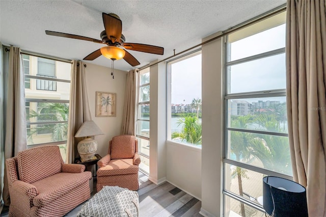 7400 Sun Island Dr S Unit 206, South Pasadena, FL 33707 - sunroom featuring wood finished floors, a textured ceiling, a water view, and baseboards