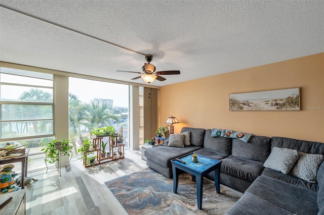 7400 Sun Island Dr S Unit 206, South Pasadena, FL 33707 - living room with wood finished floors, expansive windows, ceiling fan, and a textured ceiling