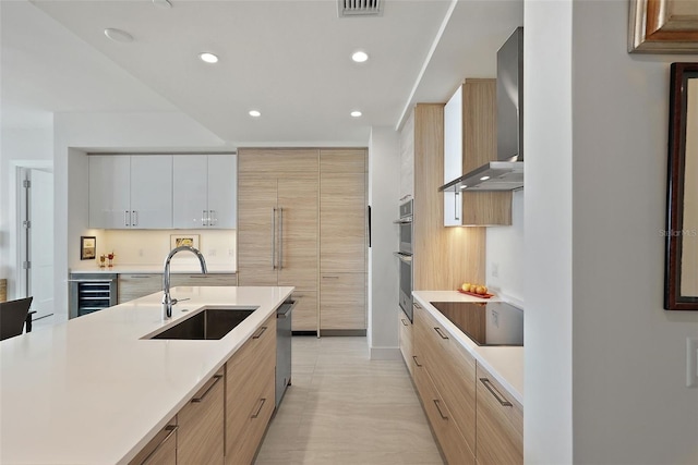 301 1st St S Unit 2305, Saint Petersburg, FL 33701 - kitchen featuring modern cabinets, a sink, wall chimney exhaust hood, light countertops, and appliances with stainless steel finishes