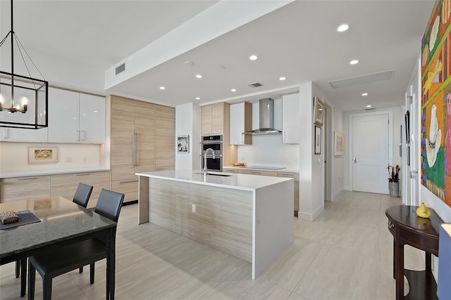 301 1st St S Unit 2305, Saint Petersburg, FL 33701 - kitchen featuring light countertops, double oven, visible vents, wall chimney exhaust hood, and modern cabinets