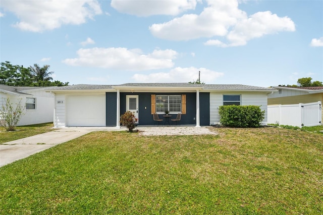 ranch-style home with an attached garage, fence, driveway, and a front yard