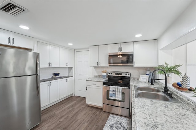 kitchen featuring backsplash, visible vents, a sink, stainless steel appliances, and recessed lighting