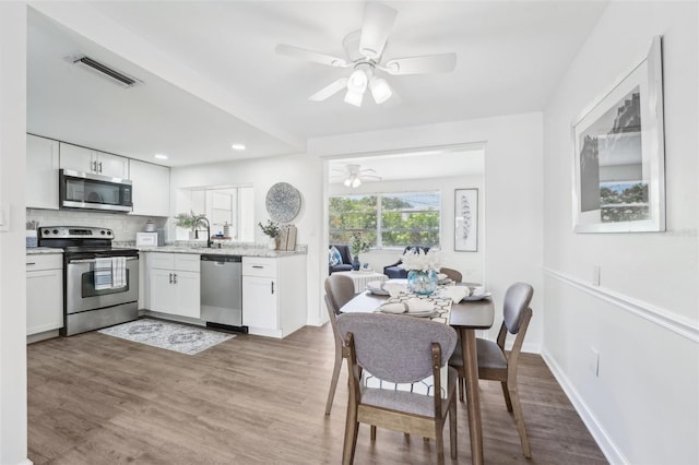 kitchen featuring visible vents, decorative backsplash, ceiling fan, white cabinets, and appliances with stainless steel finishes